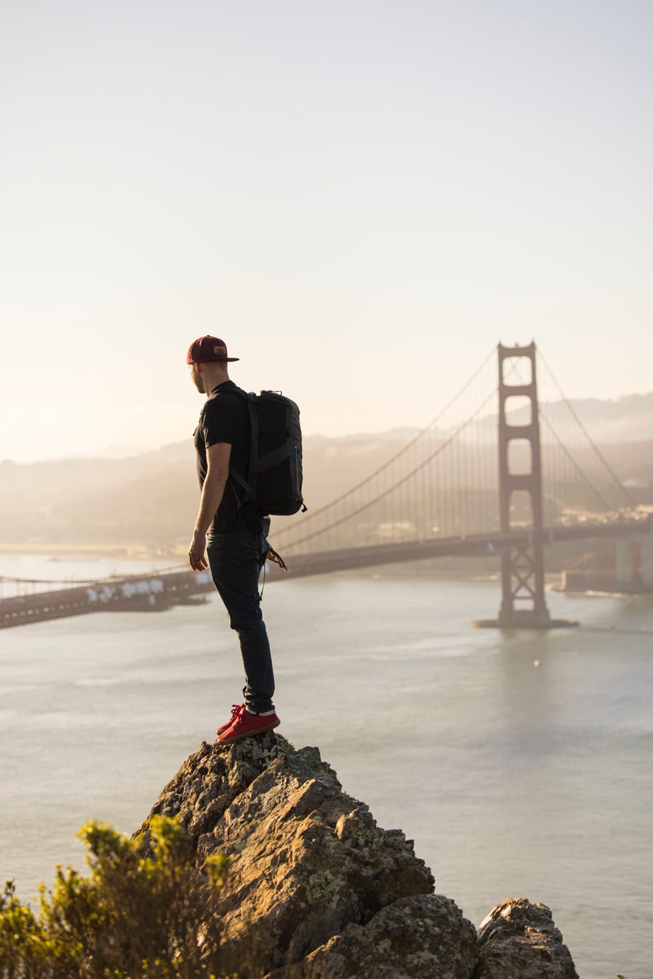 Man with backpack looking at Golden Gate Bridge